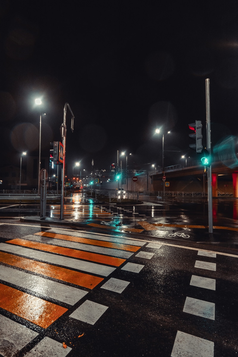 rain, road marking, zebra crossing, building exterior, light streaks, marking, highway, 5K, sign, crossing, lamp posts, no people, sky, traffic lights