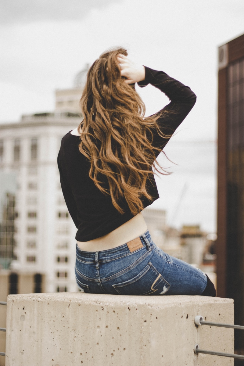 focus on foreground, one person, hair, blue, blond hair, rear view, model, lady, hand in hair, city, sitting, faded, leisure activity, person, architecture