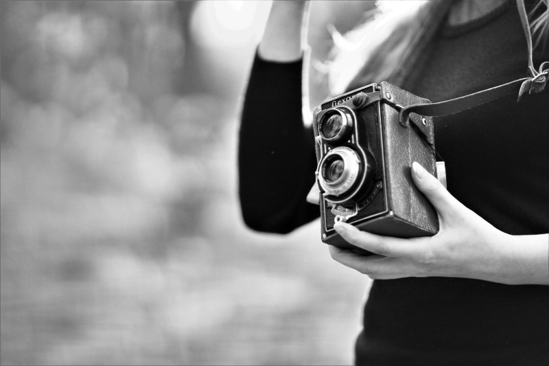 lifestyles, 5K, retro, front view, vintage camera, analog camera, hand, black-and-white, human body part, human hand, holding, focus on foreground, vintage