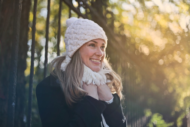 blonde, Black Jacket, hairstyle, skullcap, Sunlight, young, toothy smile, knit hat, land, happiness, Old, warm clothing, Hat, female, adult, white cap