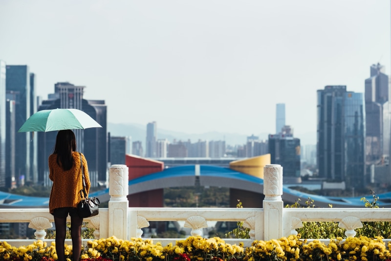 adult, rear view, skyscraper, nature, standing, facing, purse, yello, using, day, rise, looking at view, 5K, fence, black hair, cityscape, summer, lifestyles