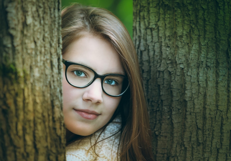 crocheted, framed, one person, eyeglasses, hairstyle, tree, people, woman, photoshoot, forest, standing, day, smiling, eyes, view, wearing, cute, young