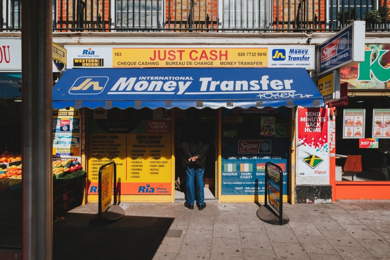 text, shop, real people, london, building exterior, architecture, bureau de change, from behind, corner shop, shadow, candid, awning, money transfer, adult
