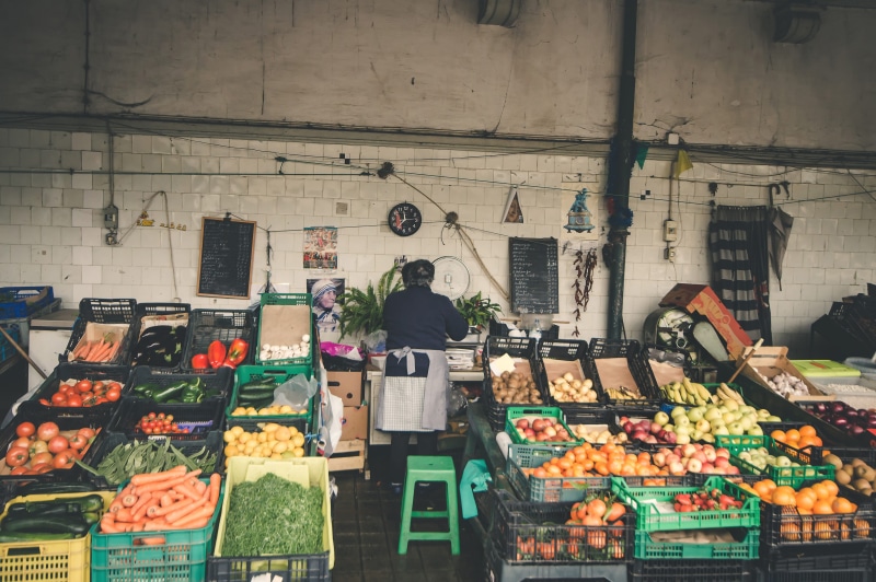 fruitstand, potato, tomato, apple, carrot, retail display, anonymous, for sale, street, market stall, woman, courgette, large group of objects, retail