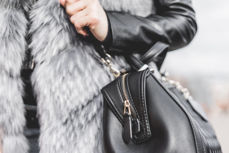 Woman, weapon, Holding, day, city, black, leather jacket, jacket, selective focus, elegance, Leather, midsection, outdoors, human hand, fashion, focus on foreground