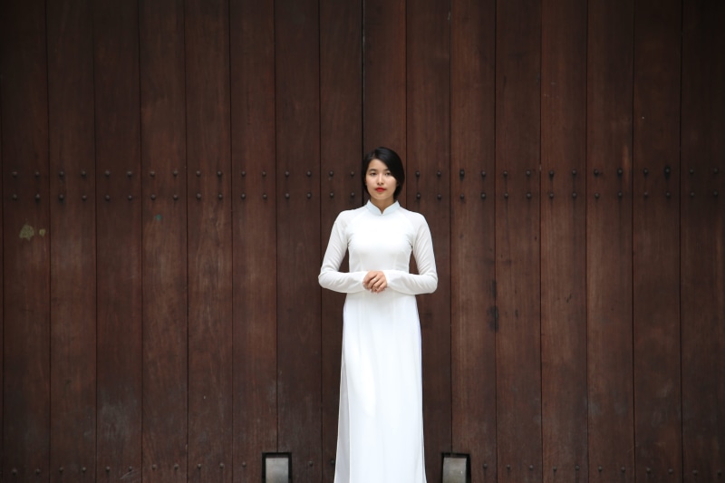 one person, adult, white, architecture, female, hair behind back, day, near, portrait, wall, centered, panneling, young adult, dress, woman, women, front