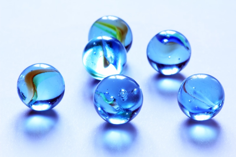 play, indoors, choice, playing, still life, blue background, multi colored, variation, selective focus, ball, no people, glass, close-up, shape, fun, white background