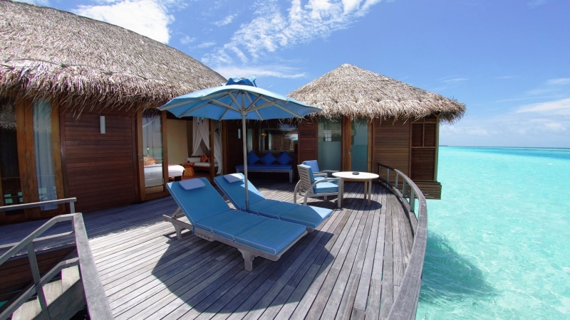 no people, tourist resort, building exterior, architecture, thatched roof, near, luxury, roof, water, built structure, body, parasol, swimming pool, blue