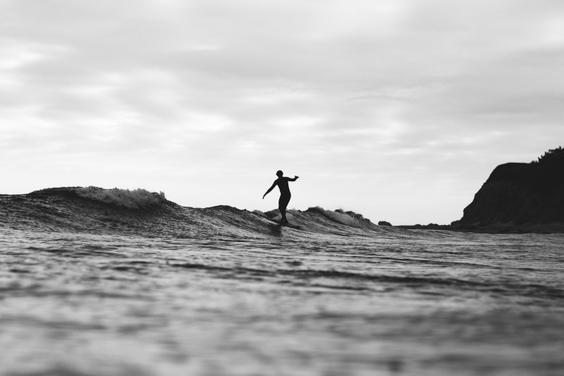 adventure, cloud - sky, water, outdoors, man, monochrome, day, balance, surf, silhouette, riding, sky, real people, surfer, human arm, activity, surfing