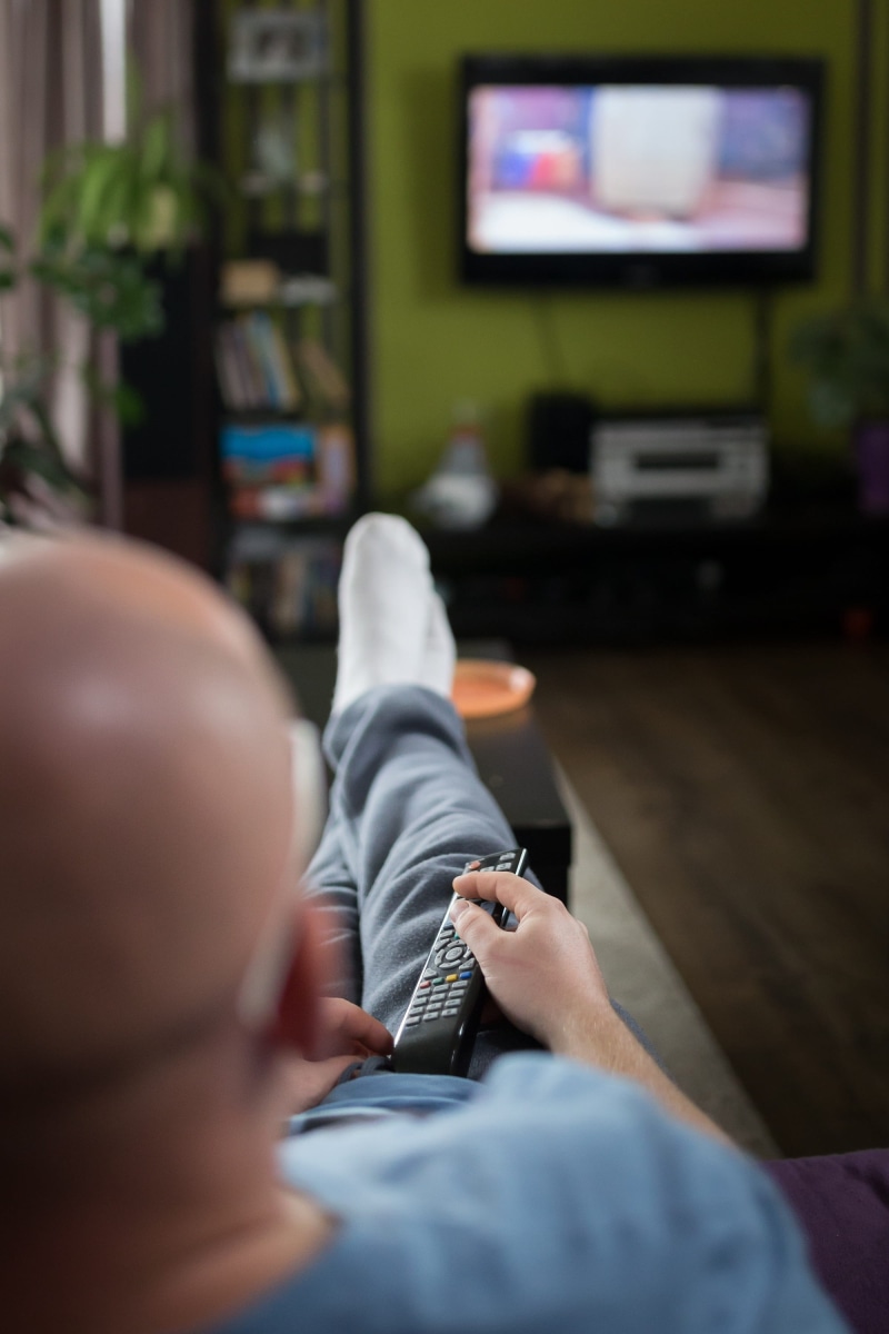 lcd, indoors, rest, lifestyles, real people, selective focus, communication, holding, relaxation, wireless technology, one person, rear view, remote, using