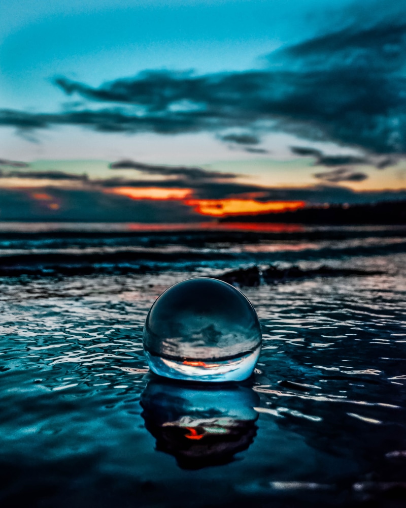 selective focus, waterfront, sphere, crystal, nature, reflections, ball, waves, clouds, reflection, sky, water, close-up, outdoors, tranquil scene, seashore