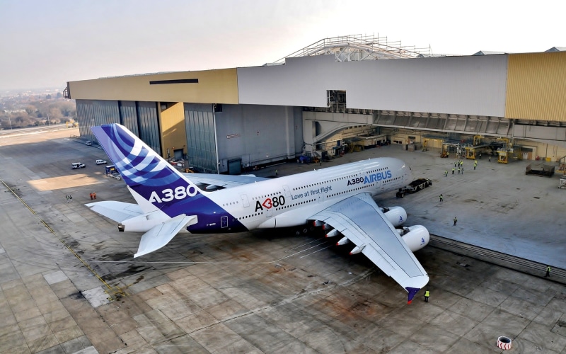 military, military airplane, outdoors, text, A380, transportation, day, aircraft, building exterior, airport, air vehicle, passenger aircraft, Airbus, airplane