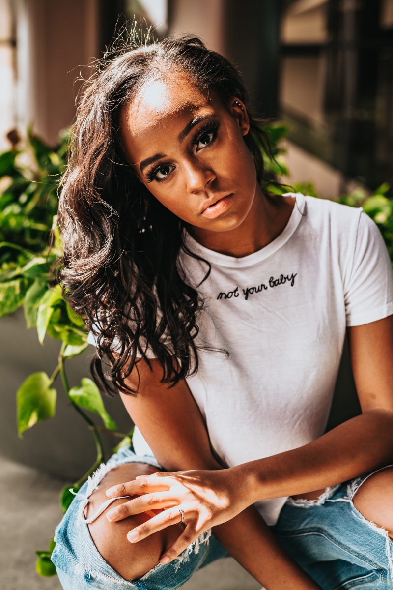 rebel, photo, bottoms, crouch, leafed, green, day, t, wearing, outdoors, african american, plant, distressed, front view, holding, one person, shirt, focus on foreground