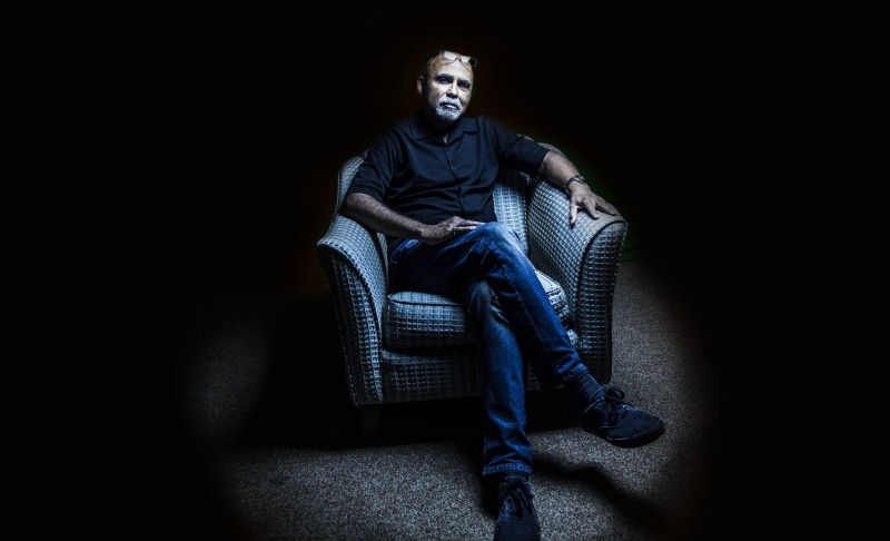 contrast, facial expression, crossing, adult, model, chair, black background, dark, mood, indoors, face, casual clothing, pose, sofa, watching, one person
