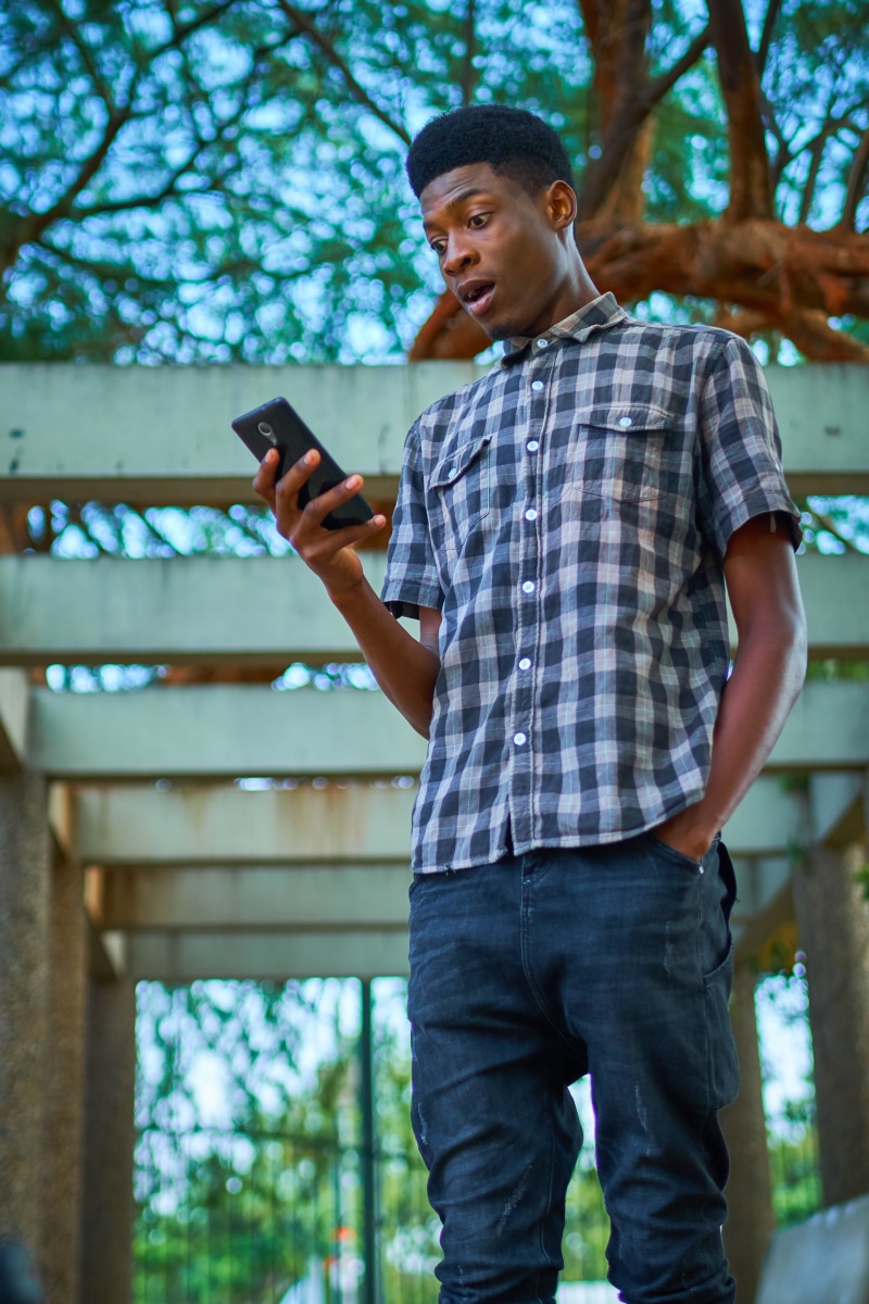 one Person, day, mobile Phone, white, teenager, connection, man, smart Phone, shirt, portable information device, wearing, standing, button, social, gray