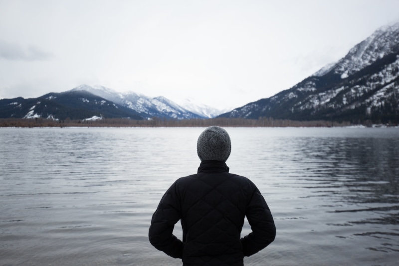 water, mountain, peaks, plants, rear view, mountains, body, wearing, beanie, gray, back, scenics, black, sky, landscape, pond, grass, jacket, snowcapped mountain