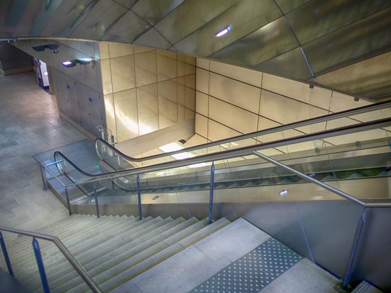 gray, lighting, interior design, moving down, railing, building, escalator, wall - building feature, vase, aluminium, stairs, technology, floor, tree, no people