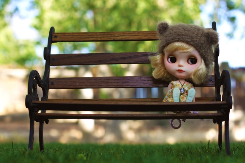 nature, sitting, childhood, looking at camera, innocence, park bench, blonde, seat, medallion, 1080P, doll, focus on foreground, grass, one person, waiting