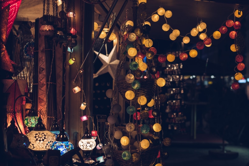 market, yellow, cultures, lights, festive, large group of objects, room, string, glow, 4K, focus on foreground, defocused, market stall, illuminated, for sale