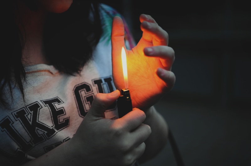 lifestyles, holding, orange color, flame, matchstick, cigarette lighter, real people, hand, human body part, women, hands, one person, finger, fire, fire - natural phenomenon