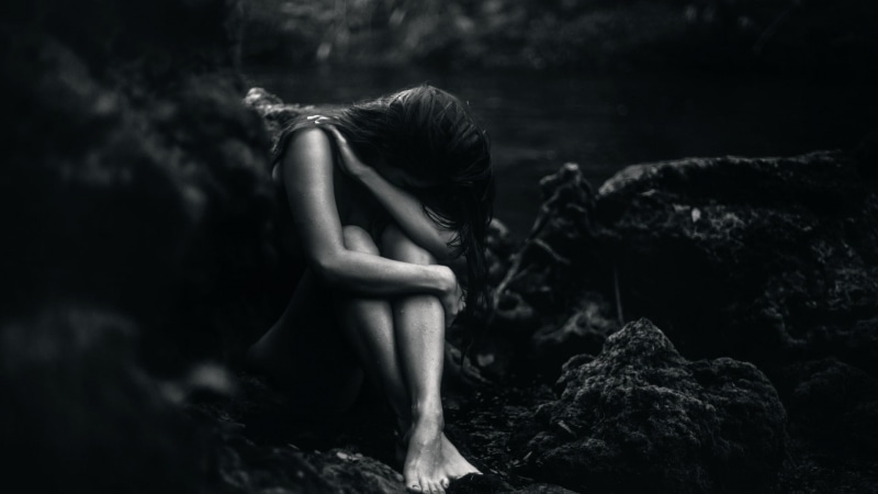 one person, rock - object, dark, hairstyle, monochrome, water, sadness, nature, emotion, side view, covered face, despair, depression - sadness, women