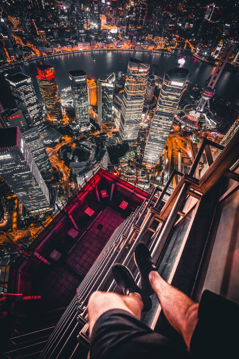 leisure activity, human body part, daredevil, cityscape, architecture, rooftop, high angle view, urban, buildings, view, aerial view, extreme, real people
