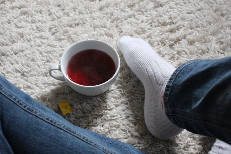 relaxation, human leg, tea - Hot Drink, adult, sock, one person, women, food and drink, day, indoors, human foot, cup, close-up, low section, Tee, rug
