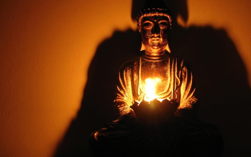 wall - building feature, spiritual, orange color, warning sign, glowing, illuminated, adult, Buddha, mystery, fire, holding, lighting equipment, light bulb