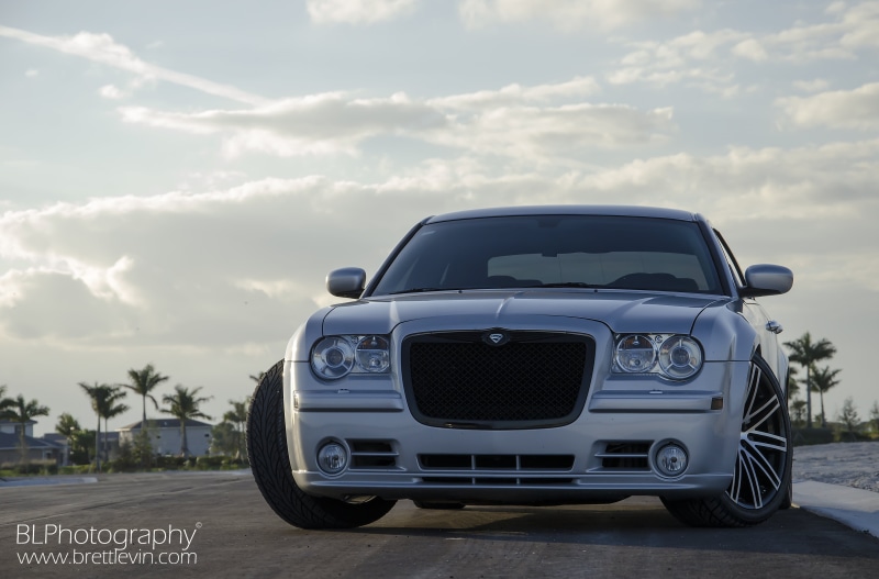 outdoors, silver, headlight, sky, transportation, auto, mode of transportation, no people, sunlight, plant, road trip, chrysler 300c srt8, car, retro styled
