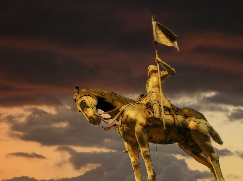 flaglet, roman catholic saint, riding, cloud - sky, human representation, the past, flag, horse, nature, Golden, france, folk heroine, city, dark skies