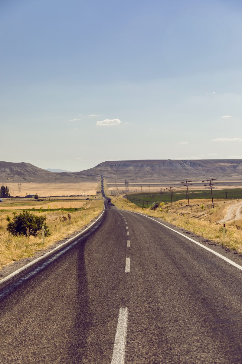 mountain, no people, monument, environment, gravel, scenery, far, filed, long, vanishing point, diminishing perspective, sky, transportation, sign, life