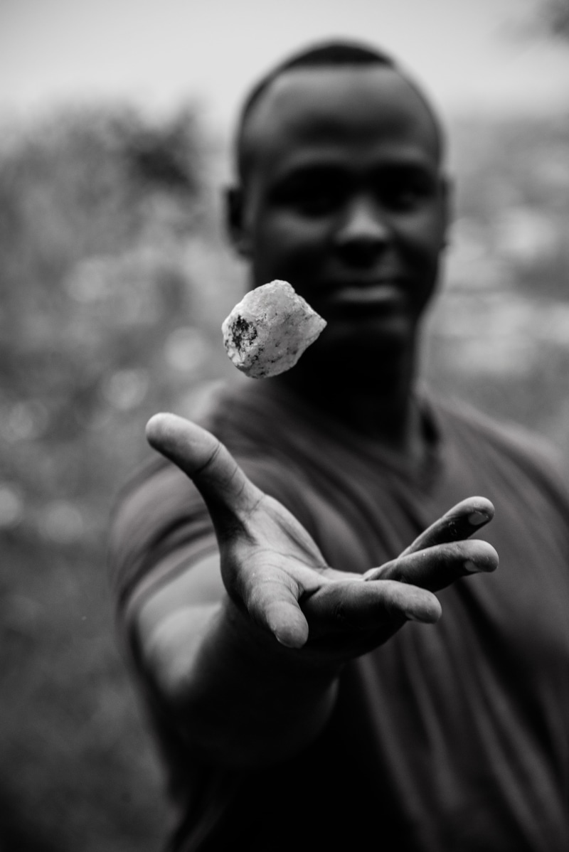 day, focus on foreground, levitate, standing, holding, people, blackandwhite, rubavu, showing, africa, one person, lifestyles, flying, real people, outdoors