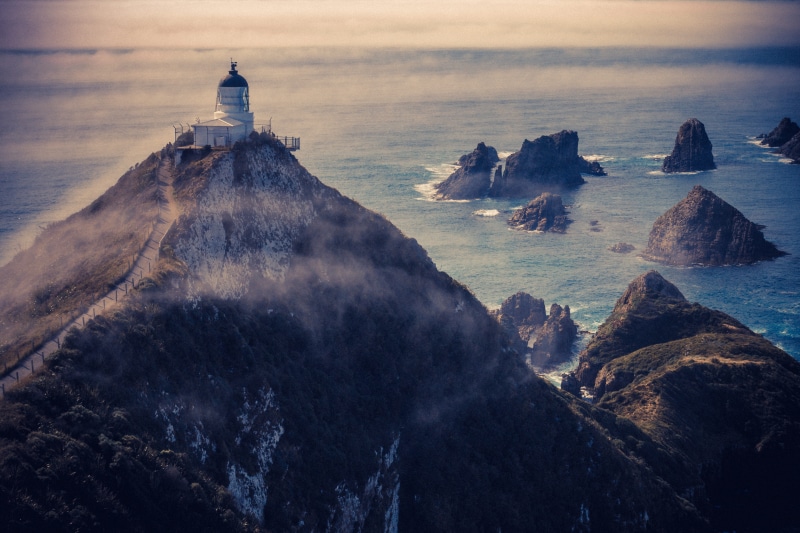 sunset, nugget point, solid, top, coast, clouds, sky, beauty in nature, building exterior, no people, ocean, near, landscape, atop, fog, white, view, cloud - sky