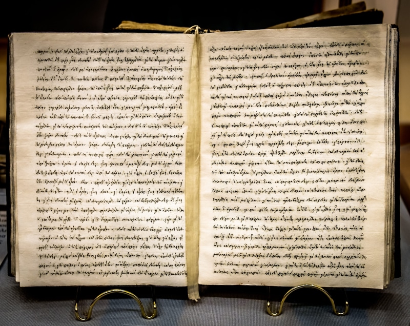 open, museum, text, indoors, page, ancient scroll, old, close-up, antique, book, paper, high angle view, belief, 2K, written, directly above, emotion
