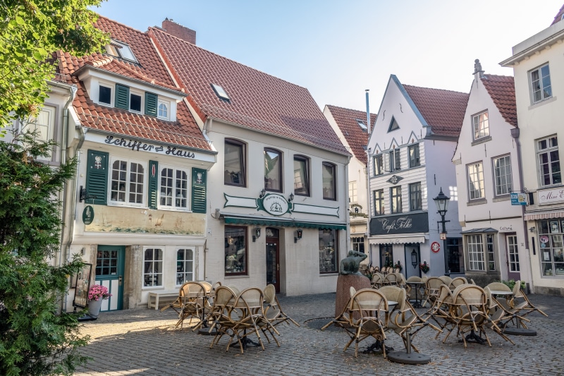 5K, outdoors, street, chair, transportation, built structure, row house, paving stones, lighting, sidewalk cafe, travel, building, cafe, seat, architecture