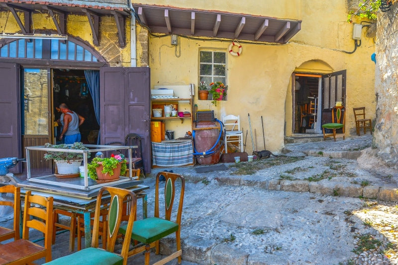 building exterior, seat, cat, outdoors, window, small business, greece, residential district, street, 2K, greek, cafe, built structure, city, chair, food and drink