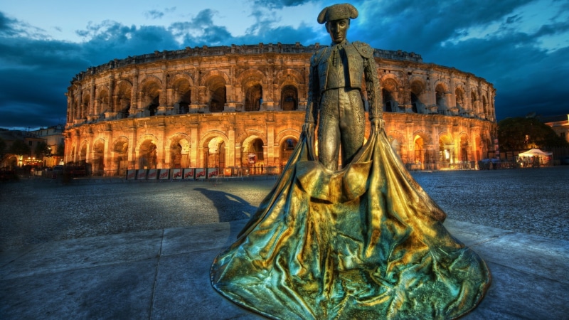 architecture, male likeness, tourism, cloud - sky, building, dusk, travel destinations, sky, lights, ancient, building exterior, Nîmes, travel, representation