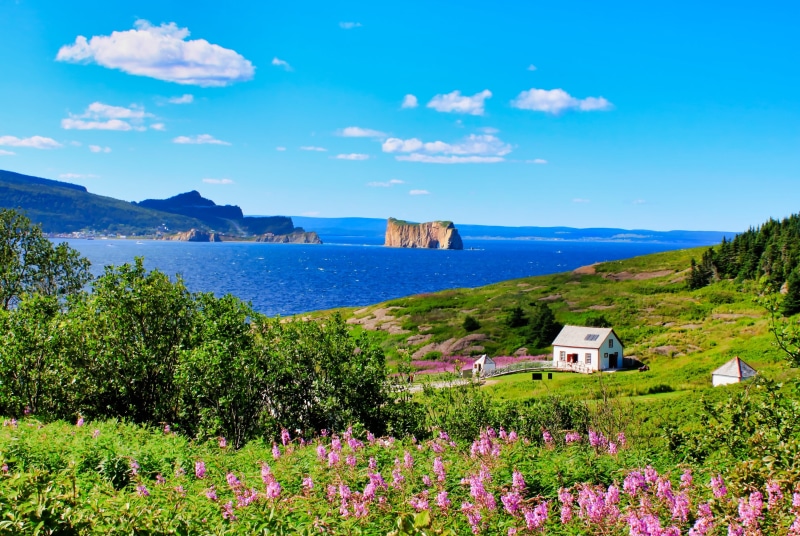 beauty in nature, building exterior, water, flowering plant, landscape, tranquil scene, day, outdoors, cloud - sky, plant, home, peninsula, land, scenics - nature