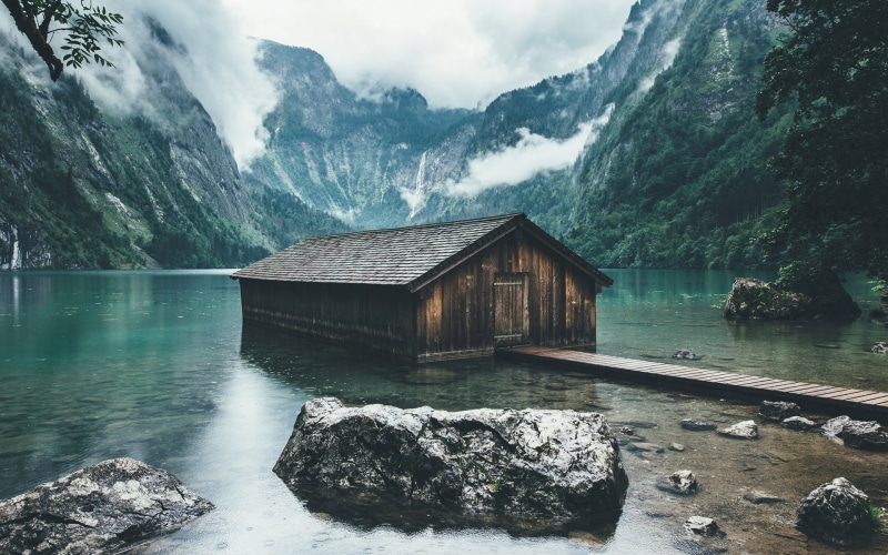 nature, scenics - nature, outdoors, boathouse, day, non-urban scene, mountains, brown, wooden, rock, mountain, rock - object, idyllic, clouds, house, sky