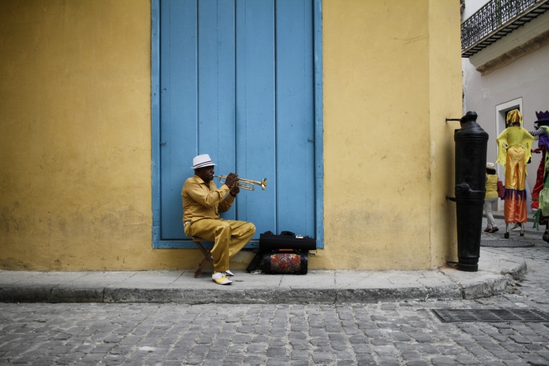 5K, social issues, warm clothing, music, day, footpath, real people, trumpet, sitting, built structure, city, cuba, casual clothing, building exterior