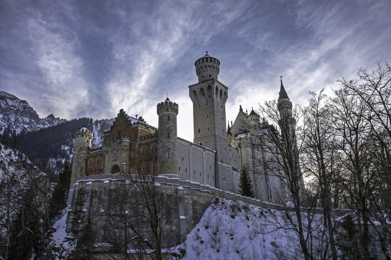 sky, tree, mountains, snow, tower, trees, castle, religion, spire, travel destinations, nature, the past, low angle view, plant, building exterior, white