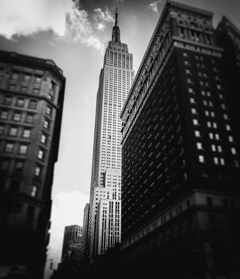 building exterior, low angle view, new york city, cityscape, new york, rise, day, cloud - sky, spire, architecture, no people, tower, building, black and white