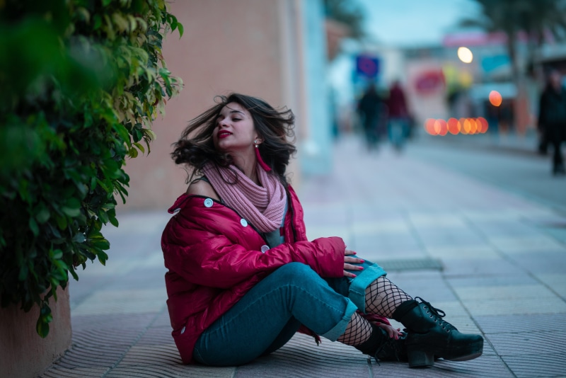 leisure activity, sitting, road, person, young adult, street, portrait, casual clothing, adult, city, focus on foreground, pose, gray, architecture, sidewalk