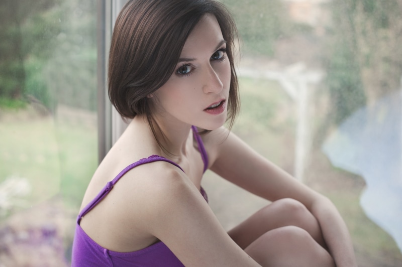 holding knees, hairstyle, brunette, real people, purple clothing, lifestyles, outdoors, portrait, women, fashion, young adult, day, focus on foreground