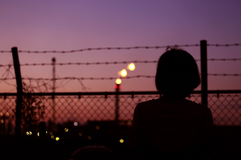 barrier, outdoors, woman, barbed wire, night, lady, female, nature, fence, front, bokeh, chainlink fence, 5K, dawn, focus on foreground, boundary, illuminated