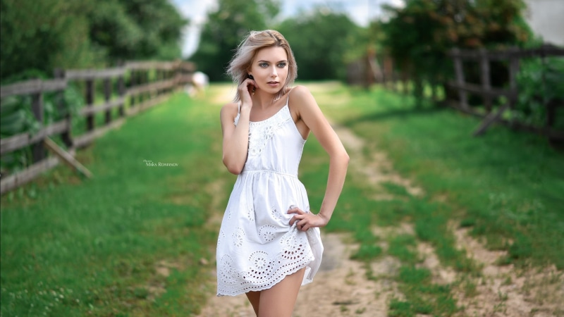 front view, young adult, beautiful woman, looking away, standing, hair, white dress, focus on foreground, hairstyle, 2K, blonde, adult, grass, dress, beauty