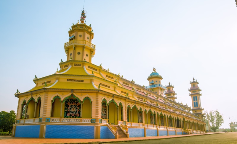 yellow, sky, temple, dome, buddha, pagoda, building exterior, sunshine, plant, clear sky, religion, built structure, city, history, travel, place of worship