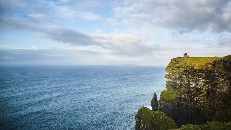 tranquil scene, non-urban scene, beauty in nature, coast, solid, landmark, day, water, nature, cloud - sky, island, brown, castle, rock, horizon, outdoors