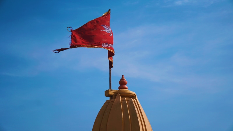 red, outdoors, pole, wind, india, low angle view, temple, pride, flag, blue, patriotism, waving, 5K, built structure, environment, clear sky, building exterior
