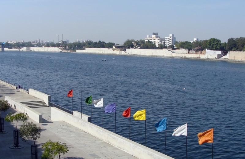 high angle view, water, riverbank, building, sabarmati, land, river, built structure, sky, travel destinations, gujarat, nautical vessel, day, building exterior